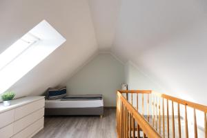 a attic bedroom with a bed and a staircase at Inselglück App 4 in Norderney