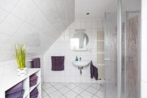 a white bathroom with a sink and a shower at Inselglück App 4 in Norderney