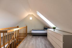 a attic bedroom with a bed and a staircase at Inselglück App 4 in Norderney
