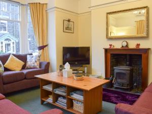 a living room with a tv and a fireplace at Blencathra House in Keswick