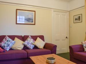 a living room with a purple couch and a table at Blencathra House in Keswick