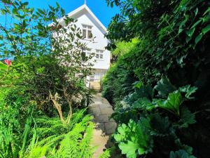 einen Garten mit einem weißen Haus im Hintergrund in der Unterkunft Haven Heights in Martinhoe
