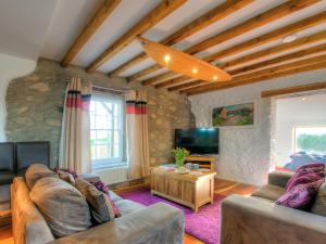 a living room with two couches and a tv at Rhosson Chapel Cottage in St. Davids