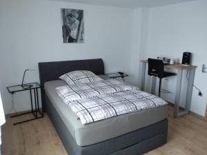 a bedroom with a bed with a plaid blanket on it at Jochen's Haus - Rooms - WiFi - TV in Siershahn