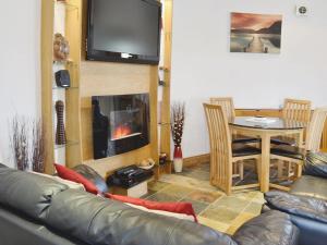 Una sala de estar con un sofá y una chimenea. en The Windmill, en Coedana