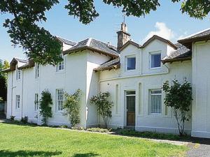 Una gran casa blanca con un patio de césped. en Lochnagar, en Largs