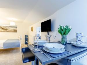 Un comedor con una mesa con platos y copas de vino. en Lake View-Uk34414, en Cheddar