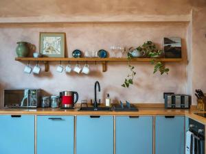 a kitchen with a counter with blue cabinets at Olive in Kelsall