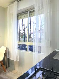 CacicedoにあるVilla Maykiのキッチン(白いカーテン付きの窓付)