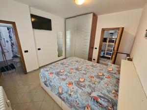 een slaapkamer met een bed met een dekbed erop bij Tana sul mare in Rimini