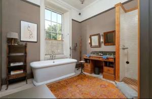 een badkamer met een bad, een bureau en een wastafel bij Elegant Georgian Retreat with Views of Arthurs Seat in Edinburgh +29 foto's