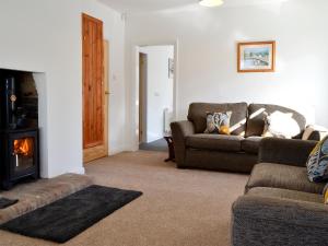 a living room with a couch and a fireplace at Wayside Cottage in Brigham