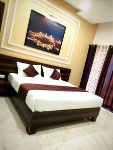 a bedroom with a bed with a television on the wall at Hotel Yashoda Palace in Kota