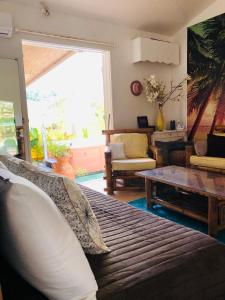 a living room with a couch and a table at Joli oasis au centre de l'île in Baie-Mahault