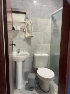 a bathroom with a toilet and a sink at Hotel Costa Rio - Conforto e Hospitalidade em Rio das ostras in Rio das Ostras