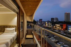 a balcony with a bed and a view of a city at Olwen Suites in Cochin