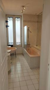a bathroom with a tub and a table and a sink at Residence Metropole Toulouse in Toulouse +17 photos