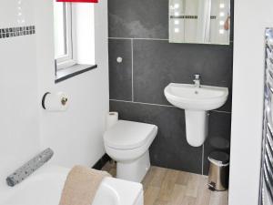 a bathroom with a white toilet and a sink at Sunset in St Austell