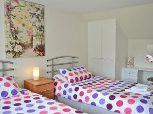 a bedroom with two beds with polka dots at The Lodge - 29794 in Swimbridge