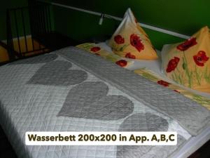 un lit avec une couette et des oreillers dessus dans l'établissement Appartements Krüger, à Hage
