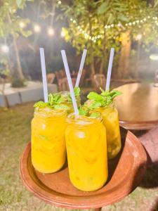 three jars of food on a plate with sticks in them at Wave Loom Hostel Ahangama in Ahangama