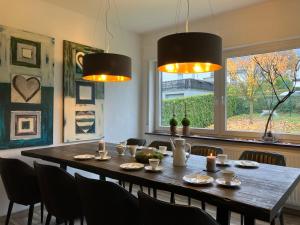 een eettafel met stoelen en 2 verlichting bij Landhaus Augenblicke in Olsberg - modernes Ferienhaus mit Garten in Olsberg