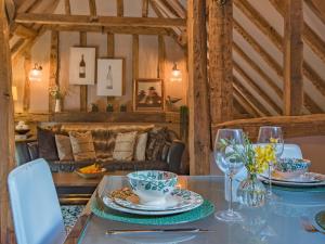 a dining room with a table with plates and wine glasses at Woolhouse Barn in Hunton