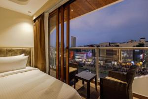 a bedroom with a bed and a view of a city at Olwen Suites in Cochin +52 photos