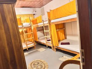 a room with bunk beds and a doorway at Wave Loom Hostel Ahangama in Ahangama