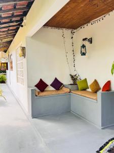 a porch with two benches with colorful pillows at Wave Loom Hostel Ahangama in Ahangama