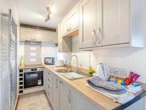 Earl SterndaleにあるPoppies Court Jericho Farmの白いキャビネットとシンクのあるキッチン