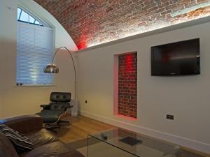 Una sala de estar con un sofá y una pared de ladrillos. en The Sergeants Quarters, Golden Hill Fort, en Freshwater