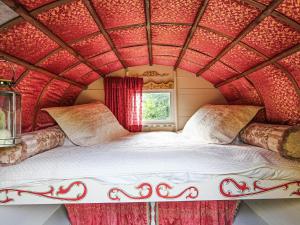 a bed in a room with a red ceiling at Copperbeech Bowtop in Tilston