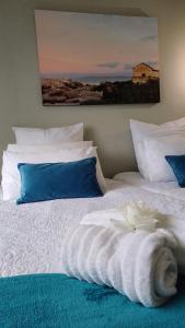 Una cama blanca con una toalla encima. en Kingfisher by the river - self catering, en Velddrif