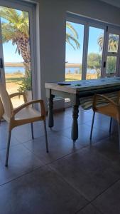 1 mesa y 2 sillas en una habitación con vistas al océano en Kingfisher by the river - self catering, en Velddrif