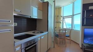 a kitchen with a sink and a table with a chair at Casa sul Mare in Vlorë