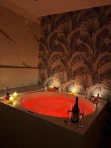 a red bath tub with candles and a bottle of wine at I Ludovici Luxury B&B in Casoria