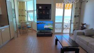 a living room with a couch and a tv and a table at Casa sul Mare in Vlorë
