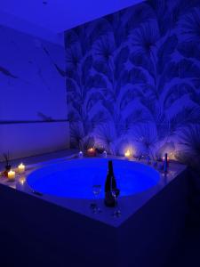 a bathroom with a blue tub with two glasses of wine at I Ludovici Luxury B&B in Casoria