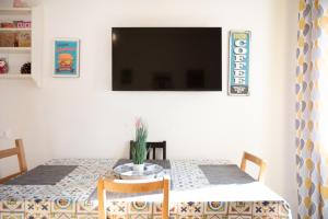 a dining room table with a tv on a wall at Loft Grazioso - Pescara in Pescara