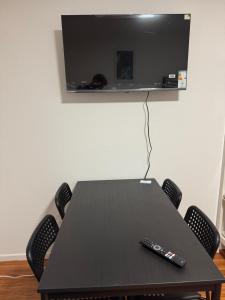 une table avec une télévision et deux télécommandes dessus dans l'établissement CityStay Dortmund, à Dortmund 6 autres photos