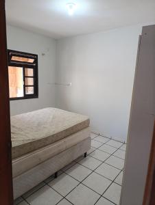 a bedroom with a bed and a window at Casa em Itapema in Itapema