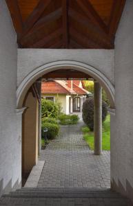 un arco sopra un passaggio in mattoni in una casa di Erdőparty Vendégház a Tápiószecső