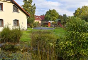 a garden with a trampoline and a playground at Erdőparty Vendégház in Tápiószecső