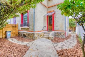 a house with a red door and a sidewalk at Maison familiale proche Paris et transport 8 personnes in Maisons-Alfort
