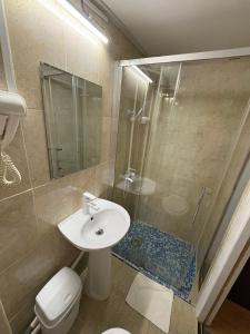 a bathroom with a toilet and a sink and a shower at Vila Ada in Bucharest