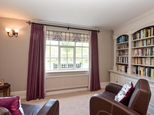a living room with a large window and bookshelves at Cravens Manor in Sotherton