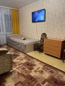 ein Schlafzimmer mit einem Bett und einem Fernseher an der Wand in der Unterkunft Апартаменти Клосовського in Schytomyr