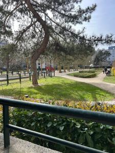 布洛涅-比扬古Idéal pour visiter Paris的围栏旁公园里的一棵树