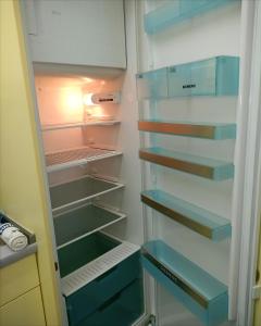 an empty refrigerator with its door open in a kitchen at Pension Am Seeberg in Alt Zeschdorf